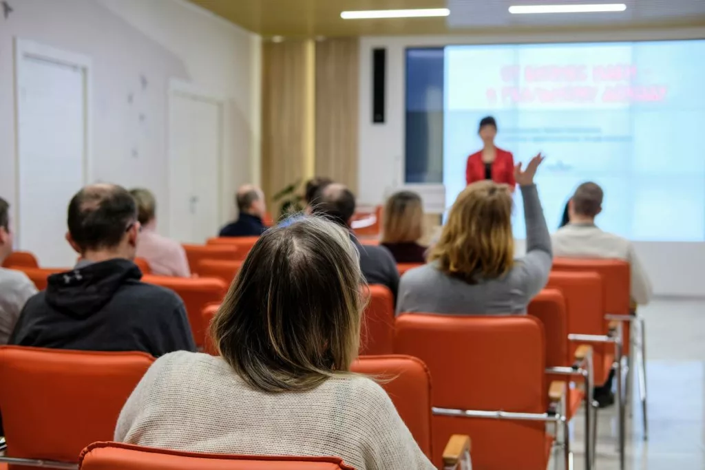 Una donna tiene una presentazione davanti a un gruppo di persone durante una sessione di formazione.