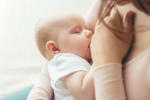Una madre nutre il suo bambino, rappresentando il concetto del permessi per allattamento