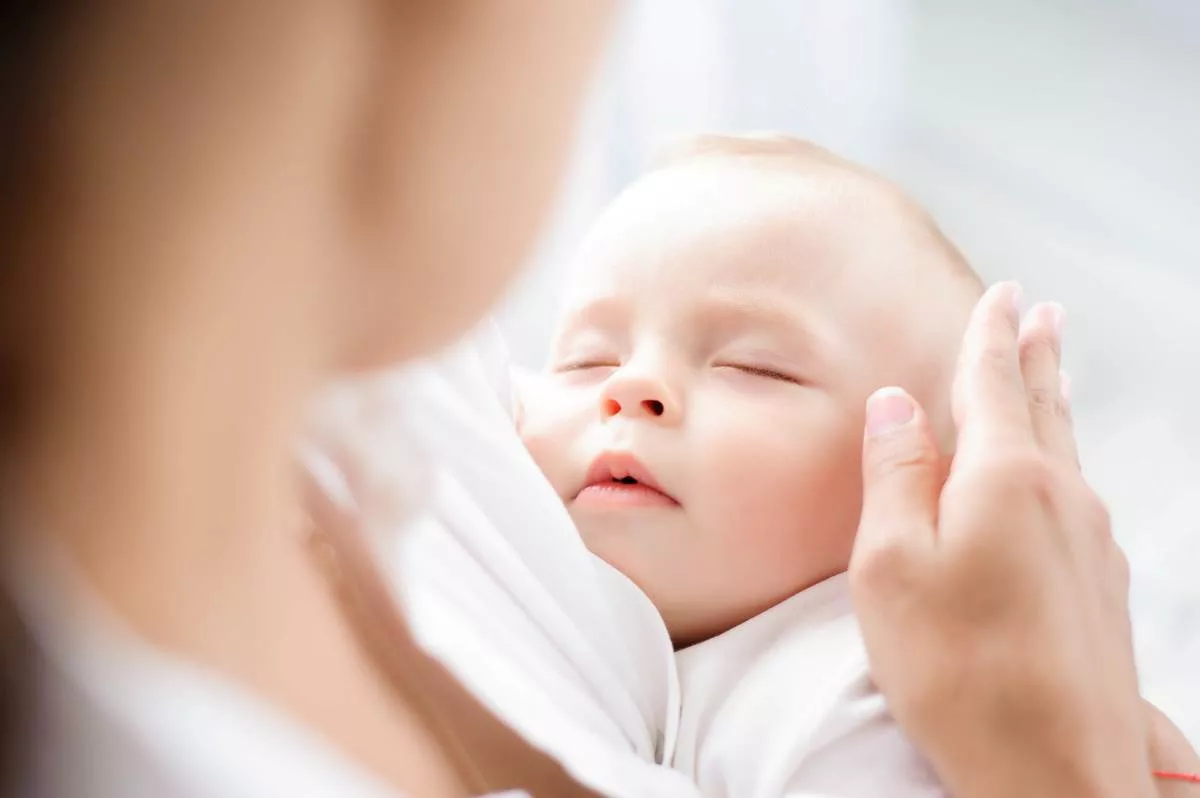 Una donna tiene un bambino tra le braccia, rappresentando il bonus cicogna