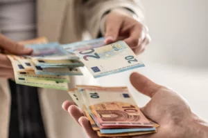 Due persone scambiano banconote euro per il bonus IRPEF 2024